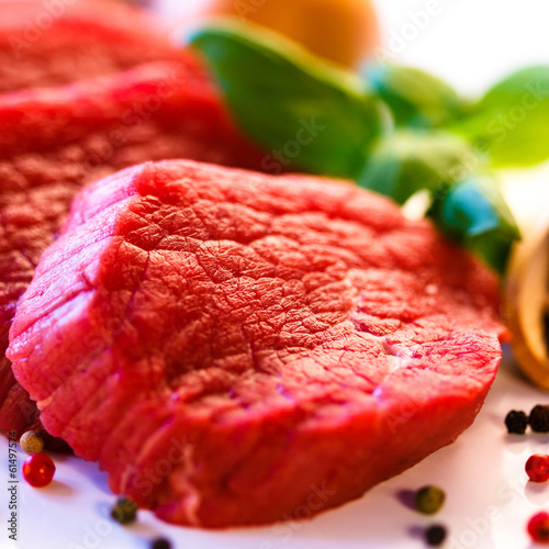 Photo: Raw beef and vegetables on white background Raw beef and vegetables on white background