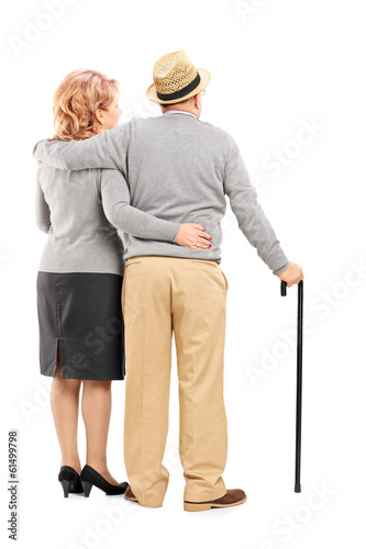 Photo: Studio shot of a happy senior couple hugging, rear view Studio shot of a happy senior couple hugging, rear view