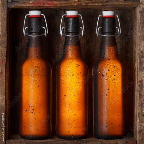 Photo: Beer bottles with vintage swing tops in old wooden crate Beer bottles with vintage swing tops in old wooden crate