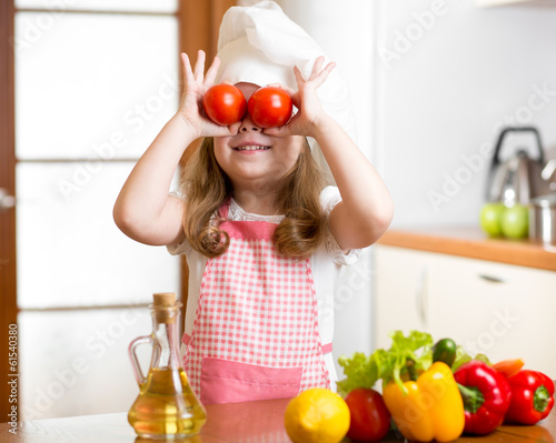 Photo: Funny chef girl preparing healthy food at kitchen Funny chef girl preparing healthy food at kitchen