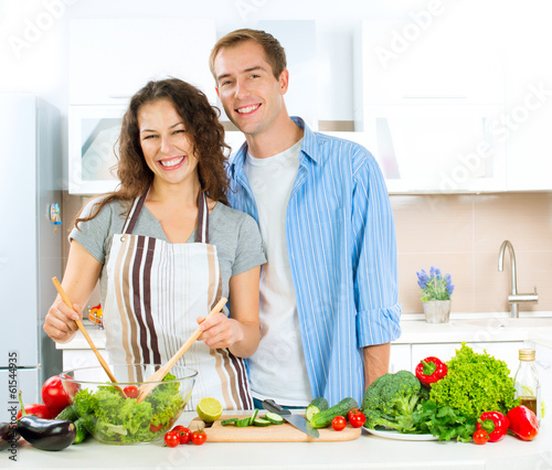 Photo: Happy Couple Cooking Together. Dieting. Healthy Food Happy Couple Cooking Together. Dieting. Healthy Food