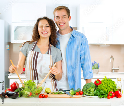 Photo: Happy Couple Cooking Together. Dieting. Healthy Food Happy Couple Cooking Together. Dieting. Healthy Food