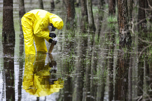 Photo: taking sample of water to container in floods contaminated area taking sample of water to container in floods contaminated area