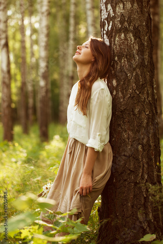 Photo: Woman leaning against birch and resting Woman leaning against birch and resting