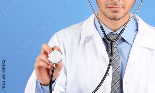 Photo: Male Doctor standing on blue background Male Doctor standing on blue background