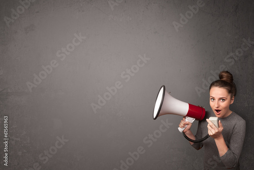Photo: Girl shouting into megaphone on copy space background Girl shouting into megaphone on copy space background