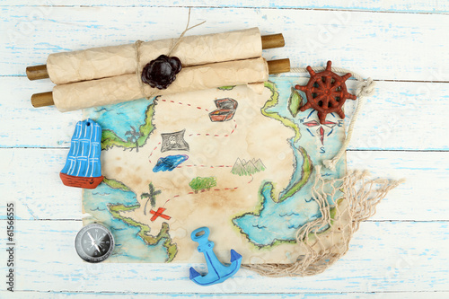 Photo: Treasure map with sea accessories, on wooden background Treasure map with sea accessories, on wooden background