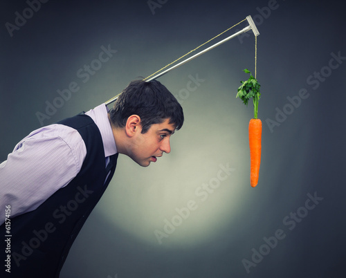 Photo: Man and carrot-bait studio shot Man and carrot-bait studio shot