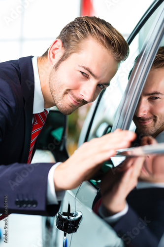 Photo: Verkäufer mit Auto im Autohaus Verkäufer mit Auto im Autohaus