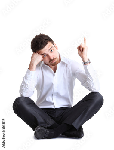 Photo: business man sitting on the floor with shocked facial expression business man sitting on the floor with shocked facial expression