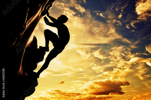 Photo: A silhouette of man climbing on mountain at sunset. Adrenaline A silhouette of man climbing on mountain at sunset. Adrenaline