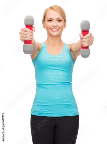 Photo: young sporty woman with light dumbbells young sporty woman with light dumbbells