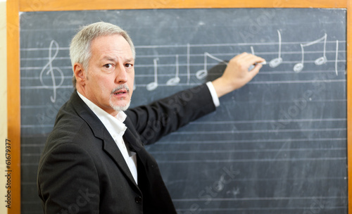 Photo: Music teacher writing notes on a blackboard Music teacher writing notes on a blackboard