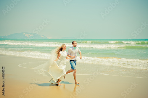 Photo: Bride and groom running on the beach Bride and groom running on the beach