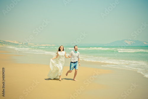 Photo: Bride and groom running on the beach Bride and groom running on the beach