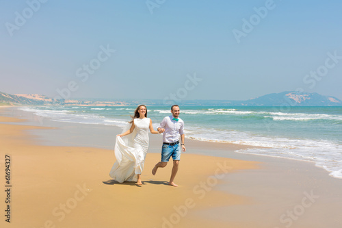 Photo: Bride and groom running on the beach Bride and groom running on the beach