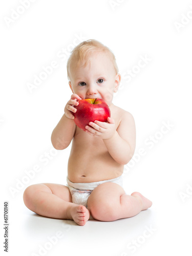 Photo: Baby boy eating red apple, isolated on white Baby boy eating red apple, isolated on white