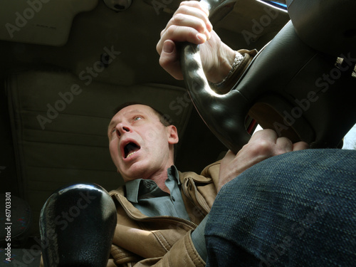 Photo: a man driving a car a man driving a car