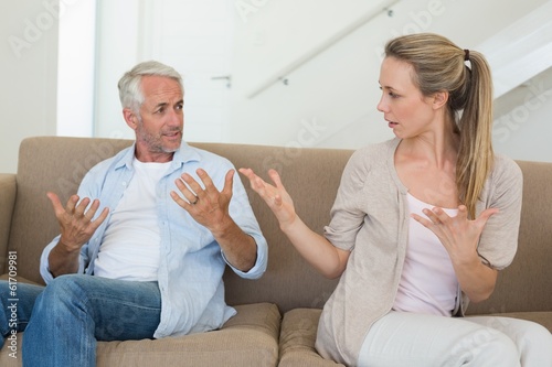 Photo: Angry couple sitting on couch arguing Angry couple sitting on couch arguing