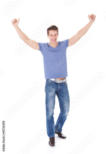 Photo: Portrait Of Excited Young Man With Hand Raised Portrait Of Excited Young Man With Hand Raised