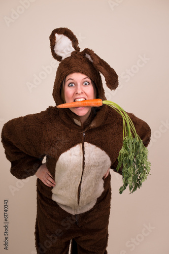 Photo: Frau im Hasenkostüm isst Möhre Frau im Hasenkostüm isst Möhre