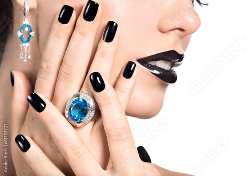 Photo: Closeup face of young beautiful woman with black manicure Closeup face of young beautiful woman with black manicure