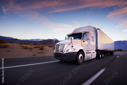 Photo: Truck and highway at sunset - transportation background Truck and highway at sunset - transportation background