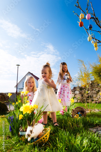 Photo: Kinder auf Ostereiersuche mit Osterhase an Ostern Kinder auf Ostereiersuche mit Osterhase an Ostern