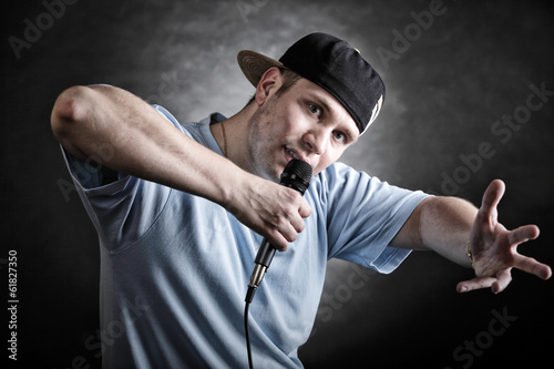 Photo: Rap singer man with microphone cool hand gesture Rap singer man with microphone cool hand gesture