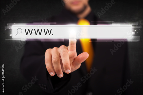 Photo: Young businessman touching web browser address bar with www sign Young businessman touching web browser address bar with www sign