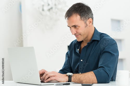 Photo: Man Using Laptop Man Using Laptop