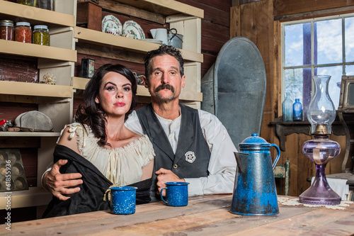 Photo: Deadpan Western Sheriff and Woman Pose Inside House Deadpan Western Sheriff and Woman Pose Inside House