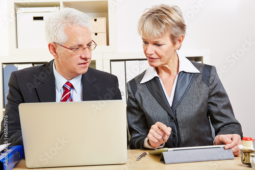 Photo: Geschäftsleute im Büro vergleichen Computer Geschäftsleute im Büro vergleichen Computer