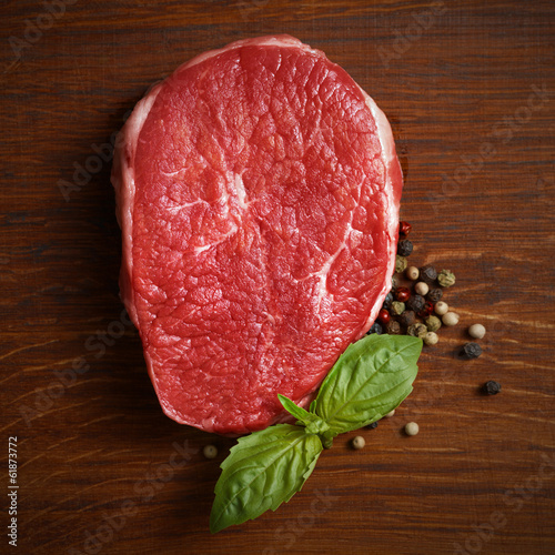 Photo: fresh raw steak with pepper and basil fresh raw steak with pepper and basil