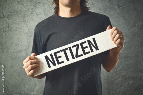 Photo: Man holding white banner with word NETIZEN printed Man holding white banner with word NETIZEN printed
