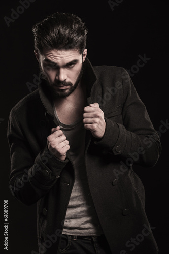 Photo: serious fashion model pulling his collar and poses serious fashion model pulling his collar and poses