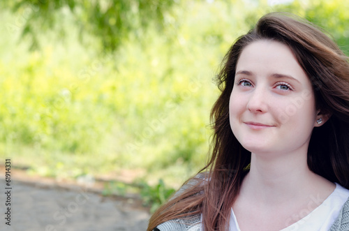Photo: Beautiful young woman daydreaming in a park Beautiful young woman daydreaming in a park
