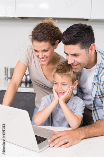 Photo: Parents using laptop with their son Parents using laptop with their son