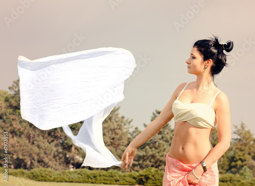 Photo: Young womans white scarf blowing away in the wind Young womans white scarf blowing away in the wind