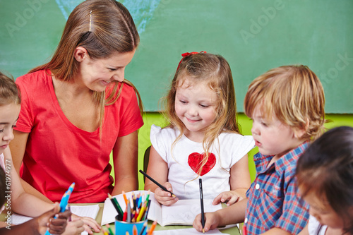 Photo: Kinder malen mit Erzieher im Kindergarten Kinder malen mit Erzieher im Kindergarten