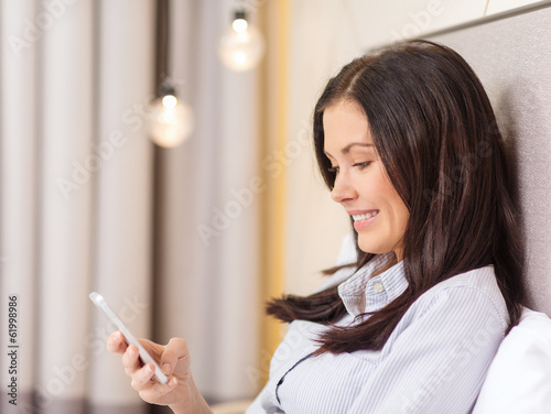 Photo: happy businesswoman with smartphone in hotel room happy businesswoman with smartphone in hotel room