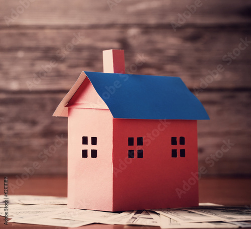 Photo: House from the paper and money on wooden background House from the paper and money on wooden background