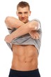 Handsome young man taking off grey t-shirt Handsome young man taking off grey t-shirt