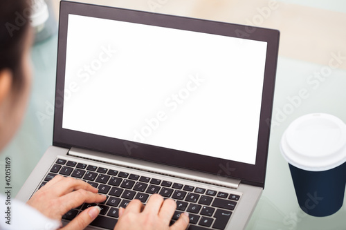 Photo: Businesswoman Working On Laptop With Disposable Cup Businesswoman Working On Laptop With Disposable Cup