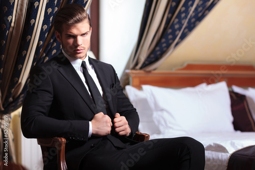 Photo: seated young business man looks at you seated young business man looks at you