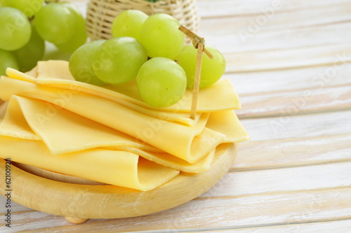 Photo: cheese served on a wooden board with green grapes cheese served on a wooden board with green grapes