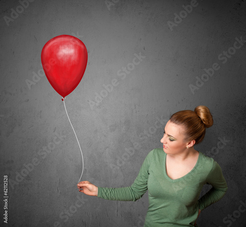 Photo: Woman holding a red balloon Woman holding a red balloon
