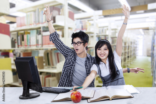 Photo: Cheerful students at library Cheerful students at library