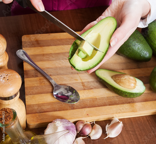 Photo: Closeup of female hands cooking with avocado Closeup of female hands cooking with avocado