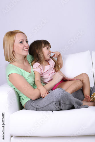 Photo: Pretty little girl sitting with mother Pretty little girl sitting with mother